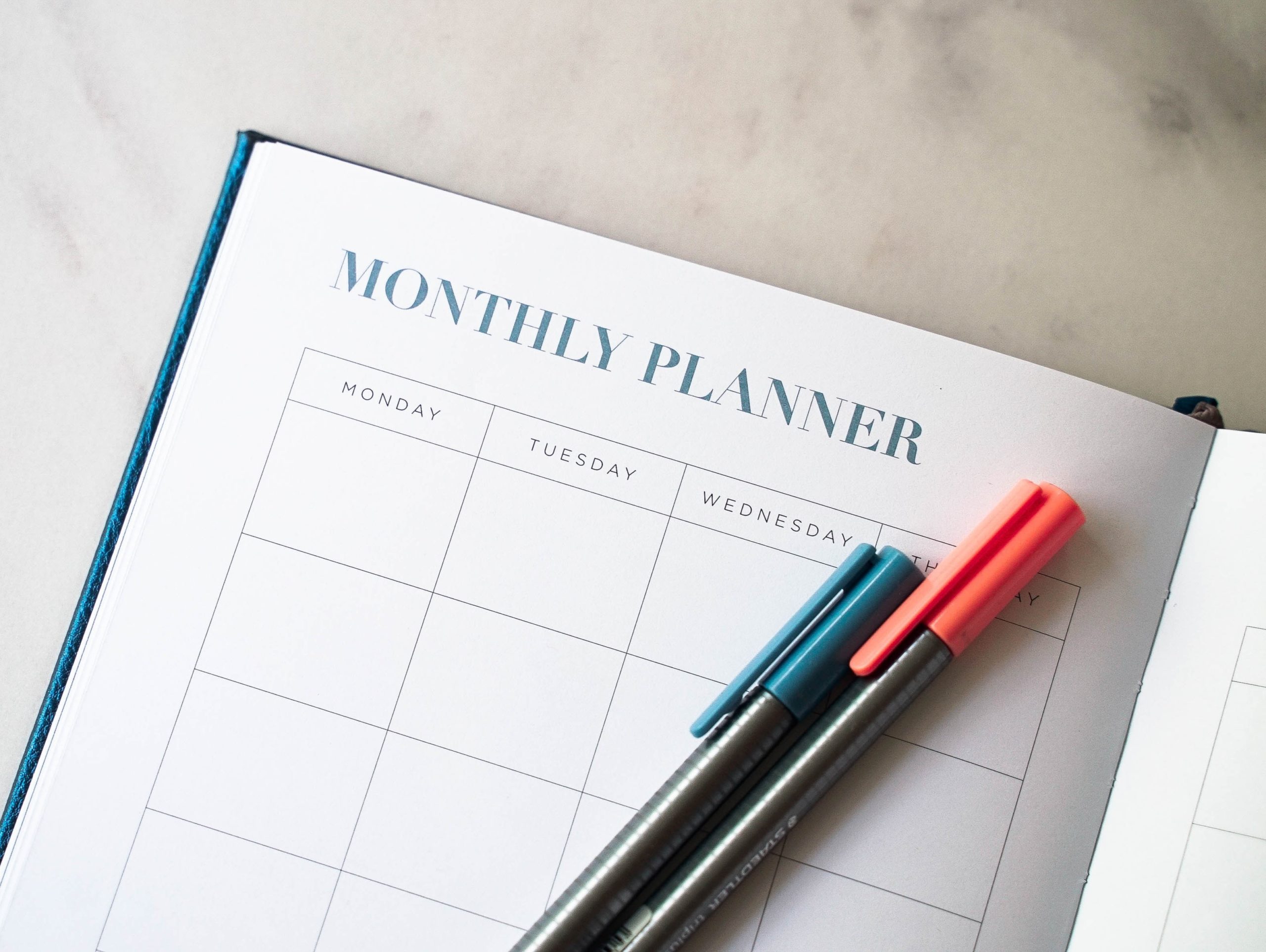 Weekly editorial calendar and notebook on a workspace
